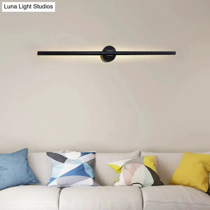 Contemporary black slim wall light fixture with round mount over a beige sofa on Tampa Home & Garden Store