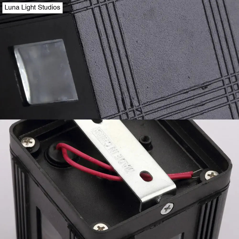Black solar lantern sconce with metal housing and exposed red wiring inside on Tampa Home & Garden Store