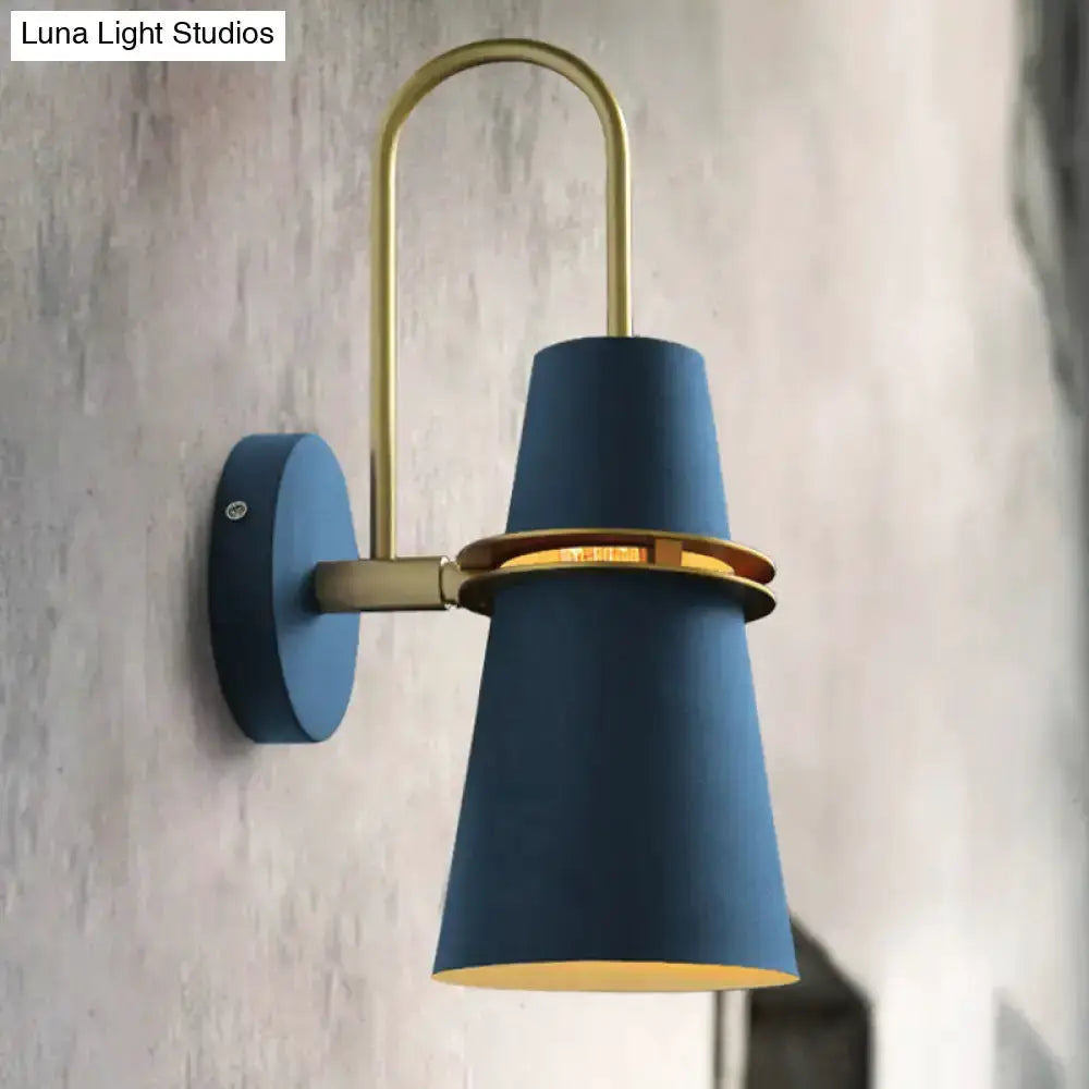 Contemporary blue and gold wall sconce with curved brass arm and flared blue shade on Tampa Home & Garden Store