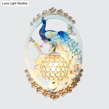 Blue Peacock Wall Sconce by Decorbites, oval frame with gold border and lit lattice lantern on Tampa Home & Garden Store