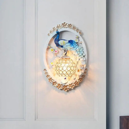 Blue Peacock Wall Sconce by Decorbites, oval frame with blue peacock above lattice lantern on Tampa Home & Garden Store