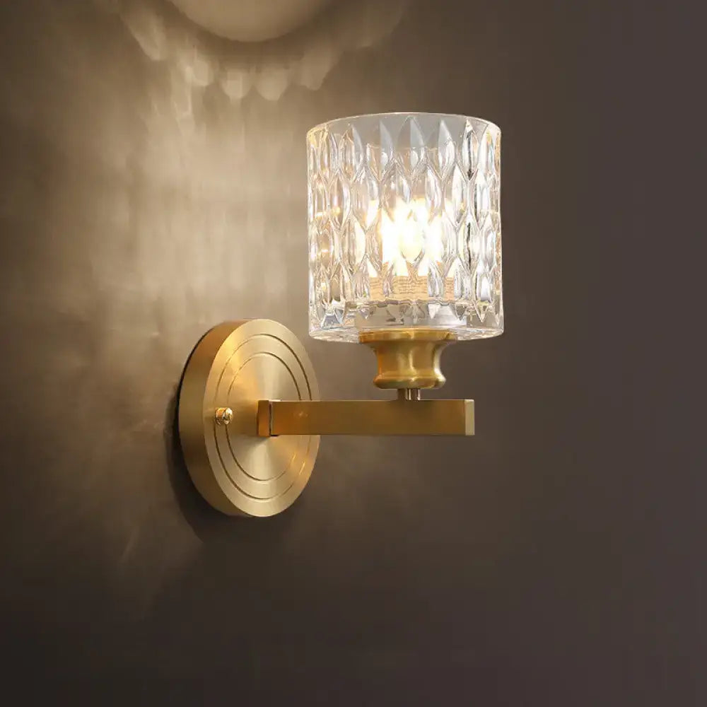 Gold cylindrical glass sconce with textured crystal shade and round wall plate on Tampa Home & Garden Store