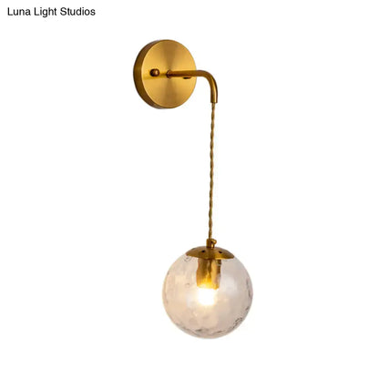 Gold Dimpled Glass Wall Lamp with hanging clear globe and brass canopy on Tampa Home & Garden Store