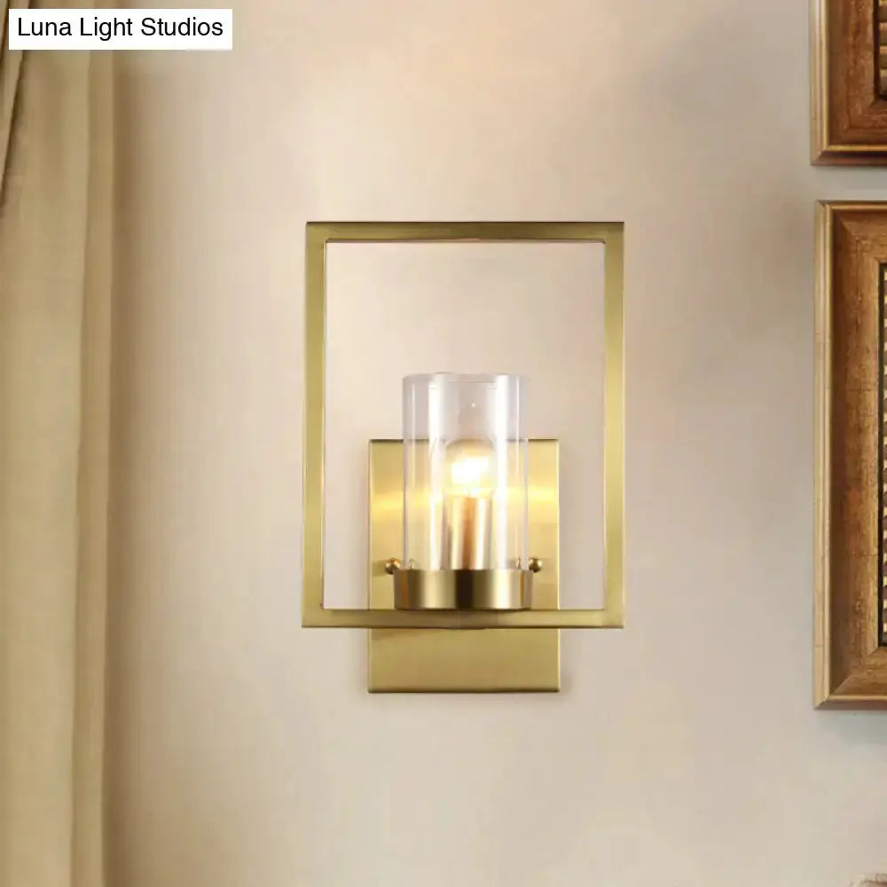 Contemporary brass wall light with clear glass cylinder inside a square frame on Tampa Home & Garden Store