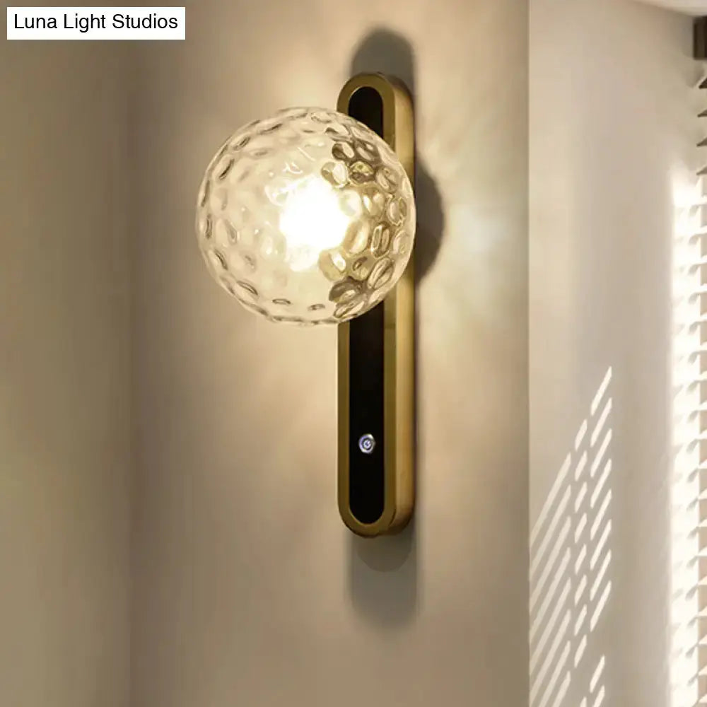 Contemporary clear glass globe wall lamp with brass mount and black panel, Decorbites sconce on Tampa Home & Garden Store