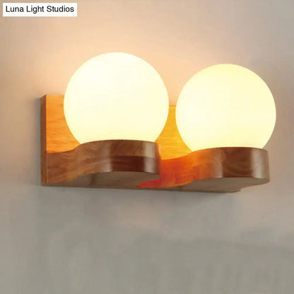 Cream glass two-globe wood sconce with curved wooden mount by Decorbites on Tampa Home & Garden Store