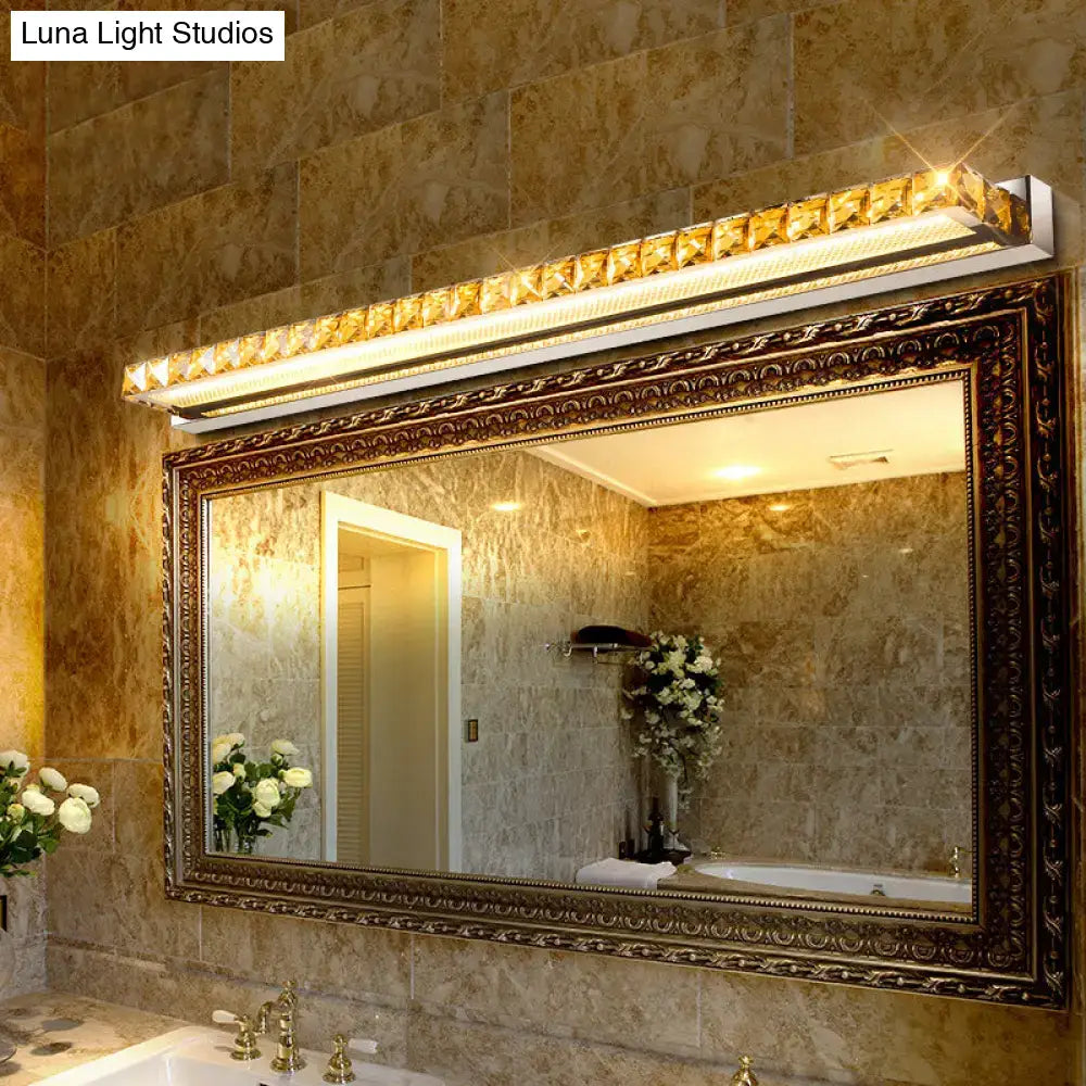 Contemporary crystal gold wall sconce with warm white LED above ornate bathroom mirror on Tampa Home & Garden Store