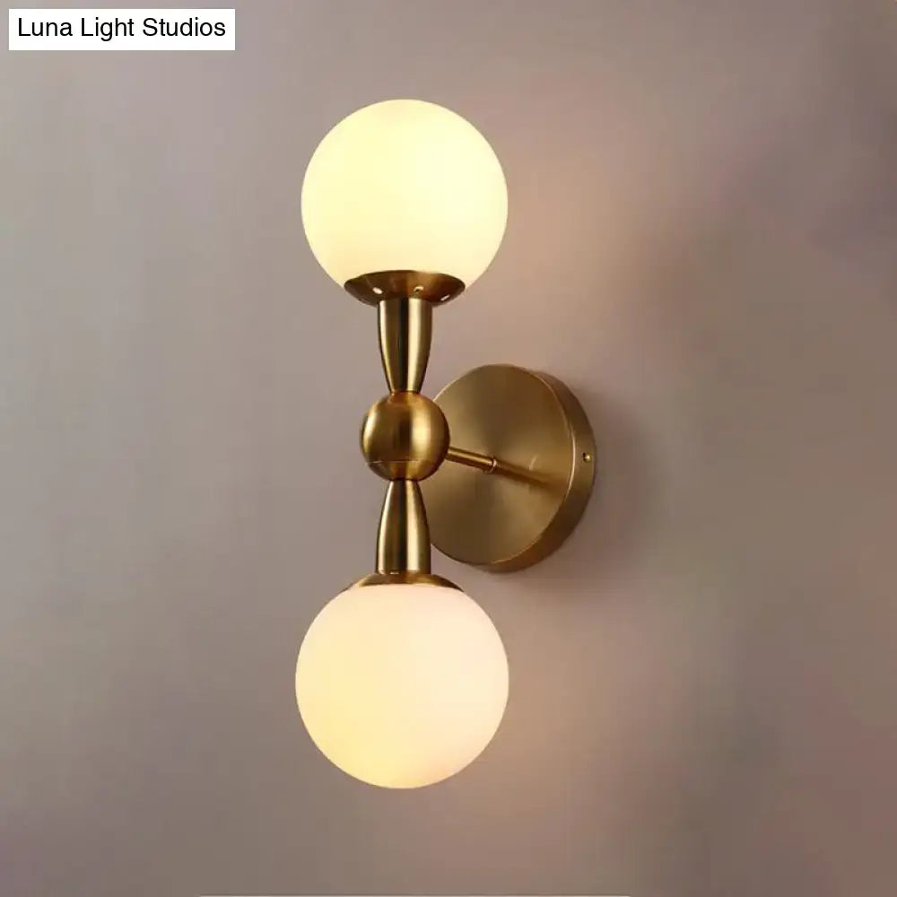 Gold white glass wall light sconce by Decorbites with brass finish and dual frosted globes on Tampa Home & Garden Store