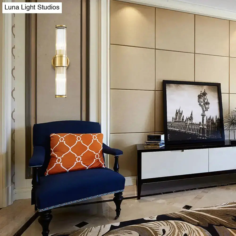Contemporary gold crystal wall sconce by Decorbites on beige wall beside navy chair on Tampa Home & Garden Store