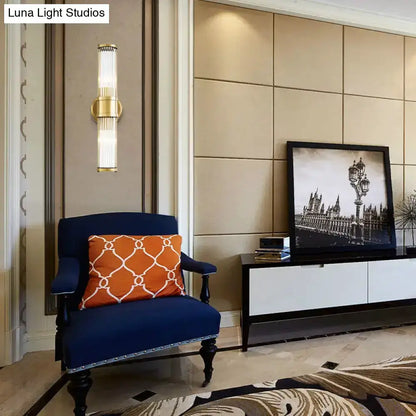 Contemporary gold crystal wall sconce by Decorbites on beige wall beside navy chair on Tampa Home & Garden Store