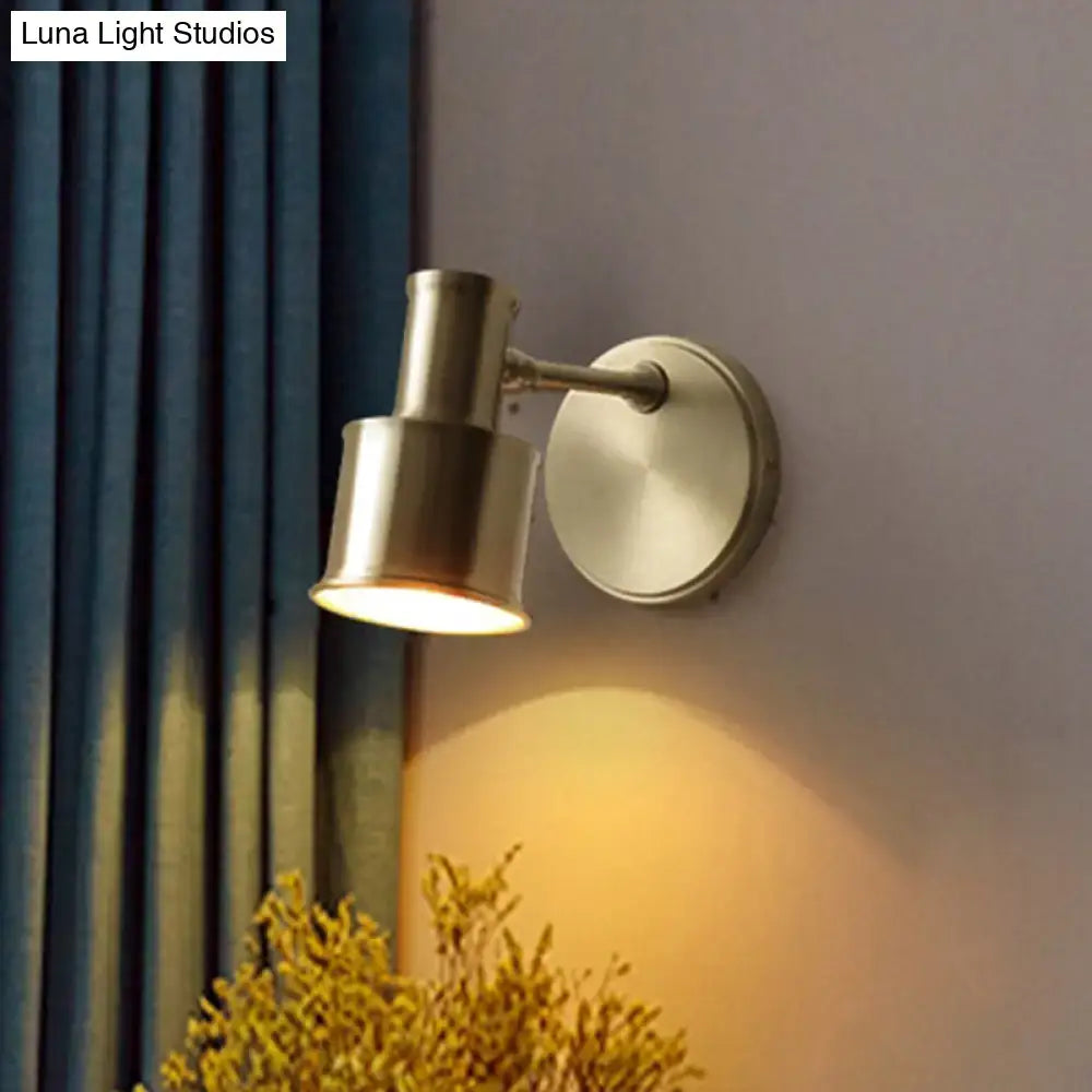 Gold cylinder wall sconce with brass finish and round backplate by Decorbites, warm light on Tampa Home & Garden Store