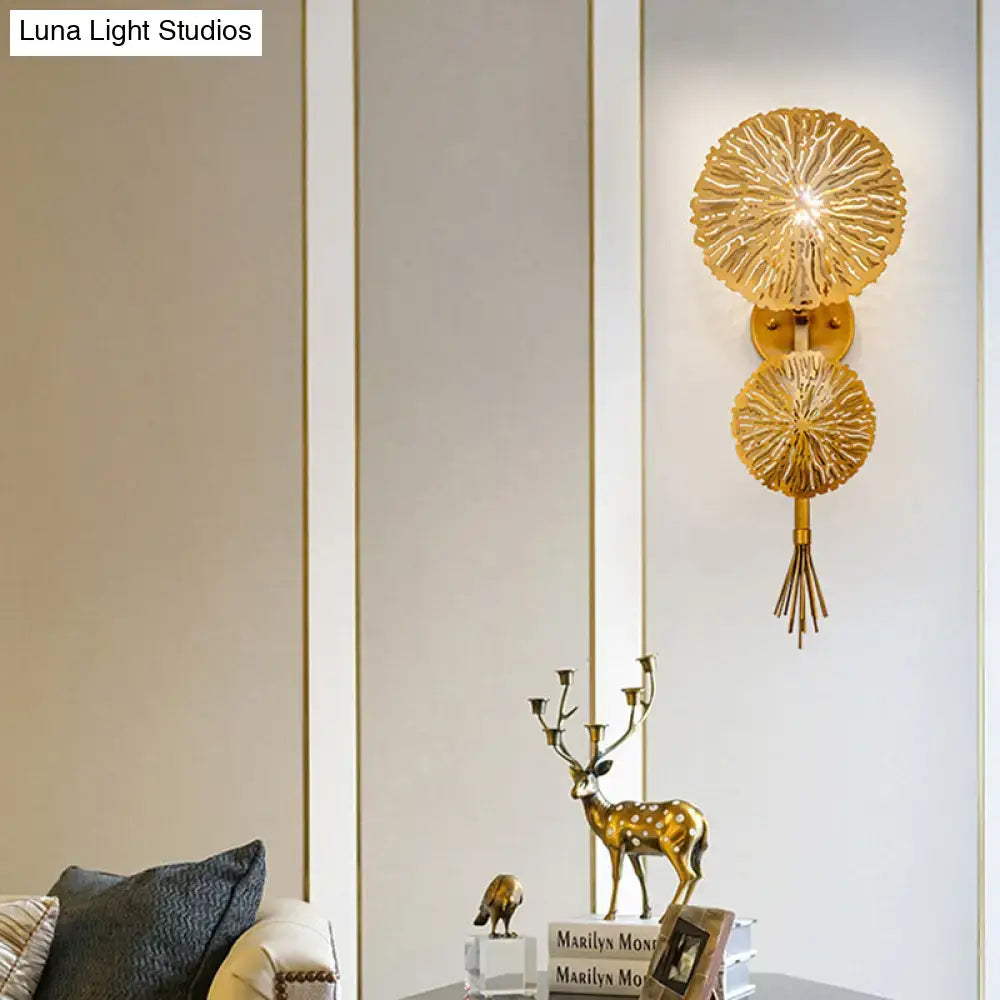 Gold sunburst wall sconce featuring two radial discs linked by a stem and a tassel accent on Tampa Home & Garden Store