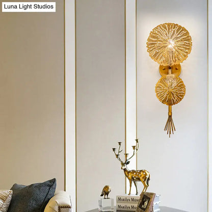 Gold sunburst wall sconce featuring two radial discs linked by a stem and a tassel accent on Tampa Home & Garden Store