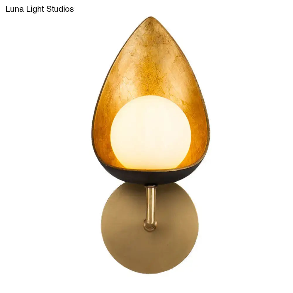 Gold teardrop glass sconce by Decorbites with warm glowing orb on brass backplate on Tampa Home & Garden Store