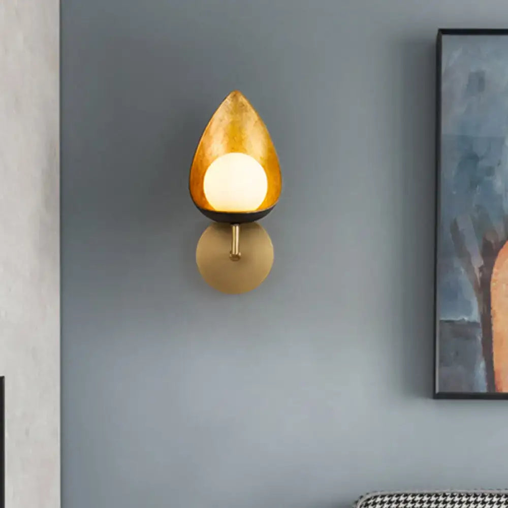 Gold teardrop glass sconce by Decorbites on brass mount with warm glow on blue wall on Tampa Home & Garden Store