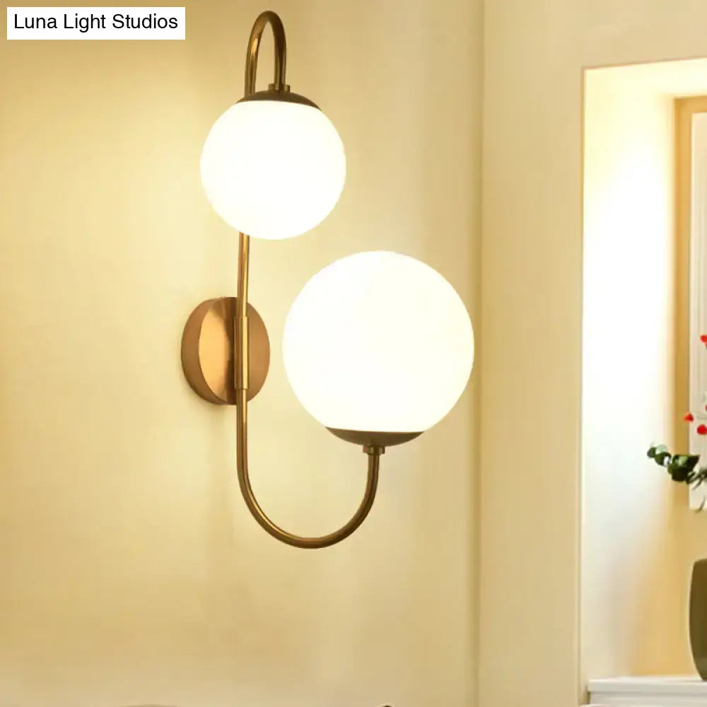 Gold opal glass ball shade dual-arm sconce by Decorbites in brass finish mounted on wall on Tampa Home & Garden Store