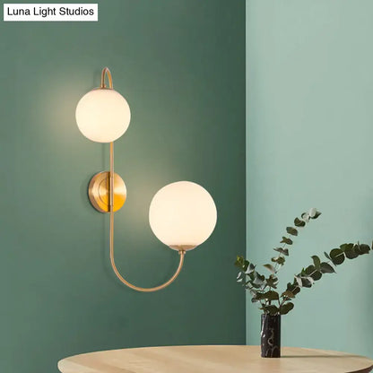 Gold opal globe 2-light wall sconce with curved brass arm by Decorbites on Tampa Home & Garden Store