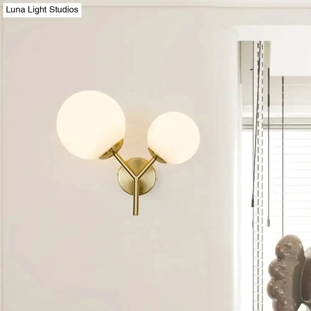Contemporary gold and white spherical glass bedroom sconce with two frosted globes on Tampa Home & Garden Store
