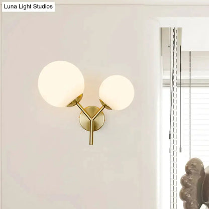 Contemporary gold and white spherical glass bedroom sconce with two frosted globes on Tampa Home & Garden Store