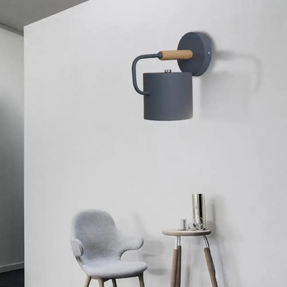 Gray metal wall sconce by Decorbites with curved arm and wood accent on round backplate on Tampa Home & Garden Store