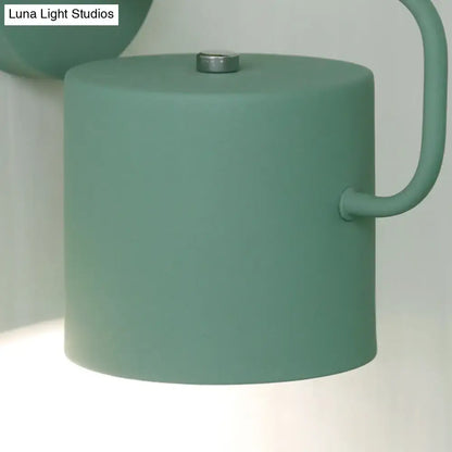 Gray metal wall sconce with matte green cylindrical shade and curved arm Decorbites on Tampa Home & Garden Store