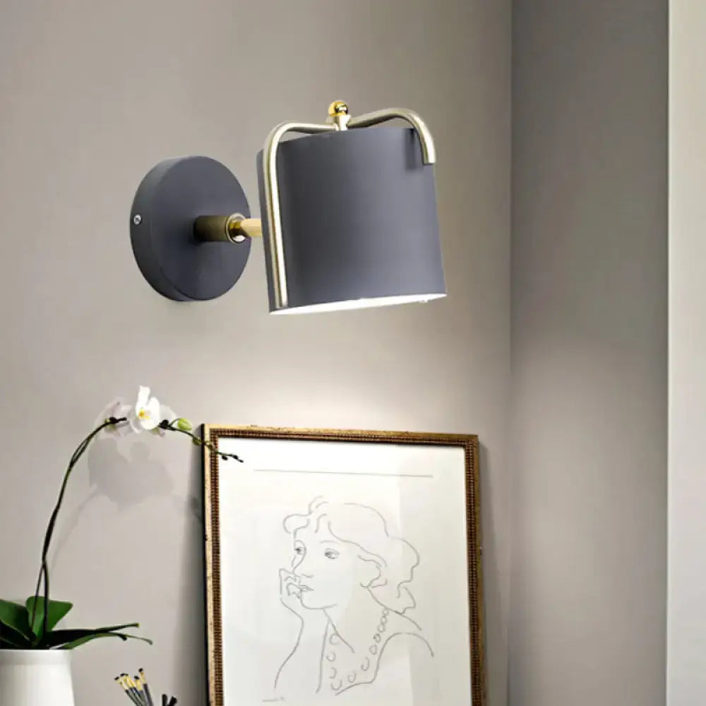 Green gray metal wall sconce with brass curved arm and gray shade on circular backplate on Tampa Home & Garden Store