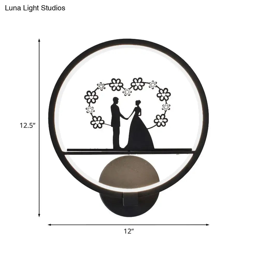 Decorbites black circular LED wall sconce with wedding silhouettes under floral heart arch on Tampa Home & Garden Store