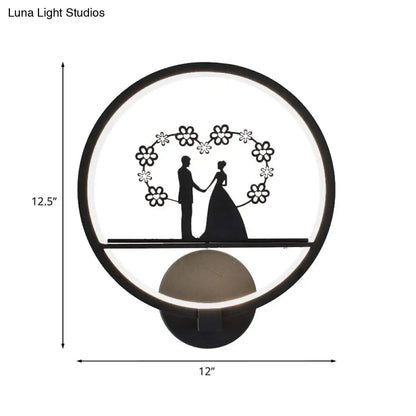 Decorbites black circular LED wall sconce with wedding silhouettes under floral heart arch on Tampa Home & Garden Store