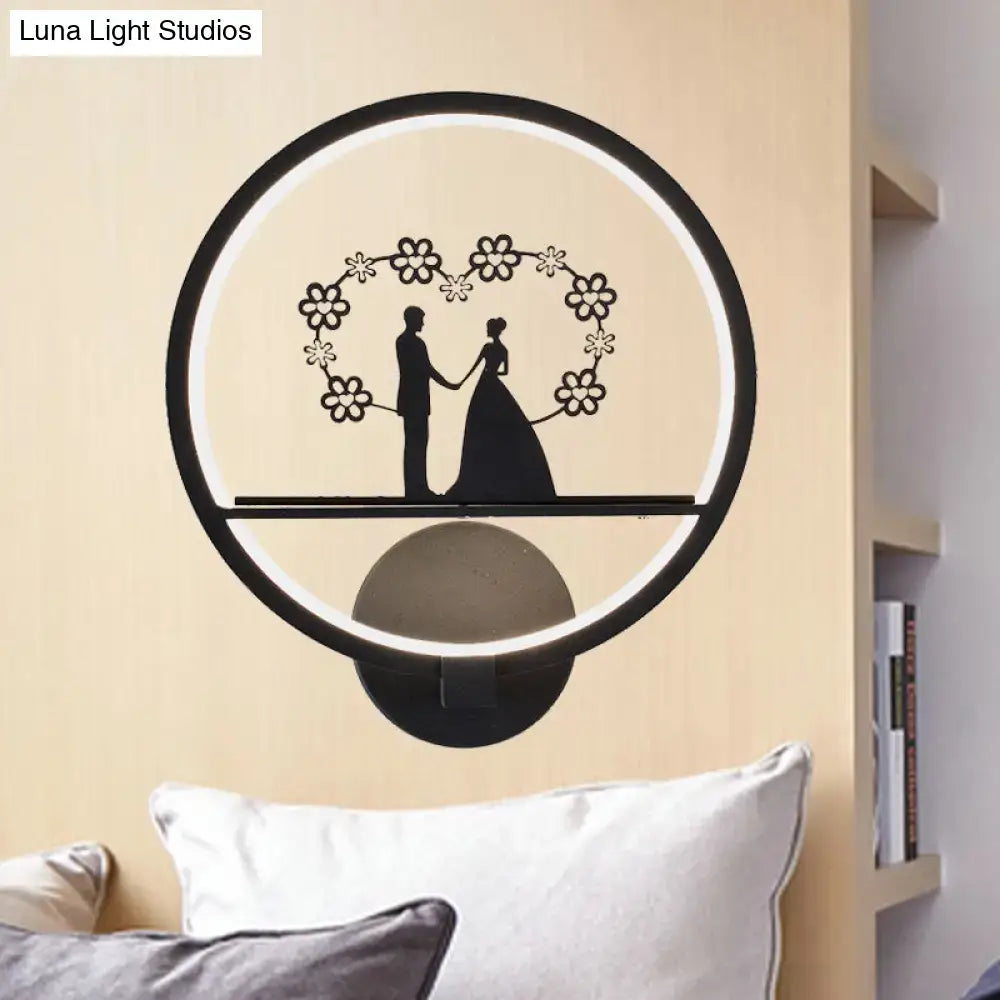Black circular LED wall sconce with couple silhouette inside floral ring and halo light on Tampa Home & Garden Store