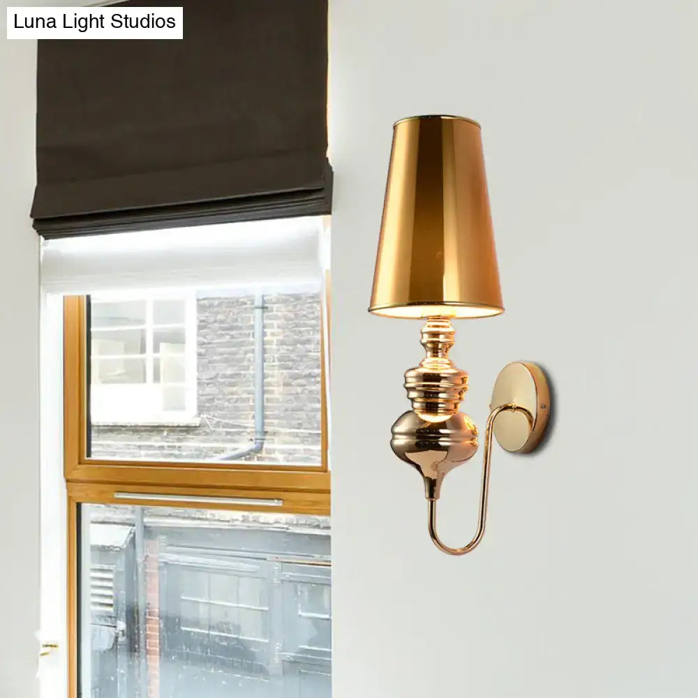 Gold metal wall sconce with ornate bulbous base and curved arm, brass finish on Tampa Home & Garden Store