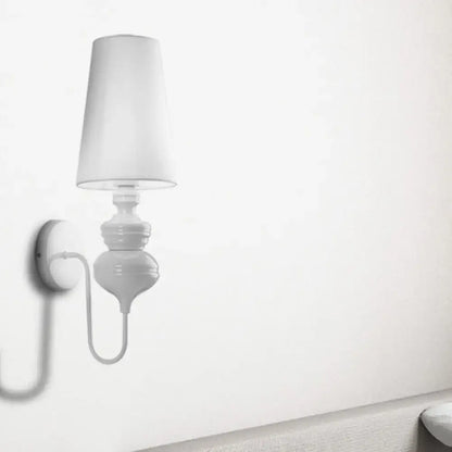 White fabric shade wall sconce with ceramic pedestal and curved arm on wall on Tampa Home & Garden Store