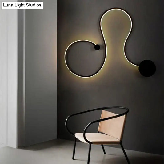 Black metal wall sconce with illuminated white edge and twist loop silhouette by Decorbites on Tampa Home & Garden Store