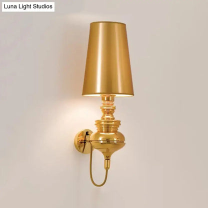 Gold brass wall sconce with tall tapered shade and ornate stacked stem on Tampa Home & Garden Store