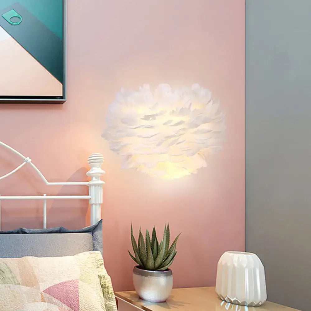 White feather single bulb sconce by Decorbites with soft glow on pink wall on Tampa Home & Garden Store