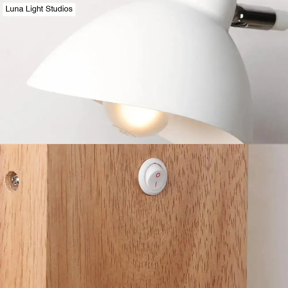 White metal wood sconce with a white dome shade mounted on wood back panel, warm glow on Tampa Home & Garden Store