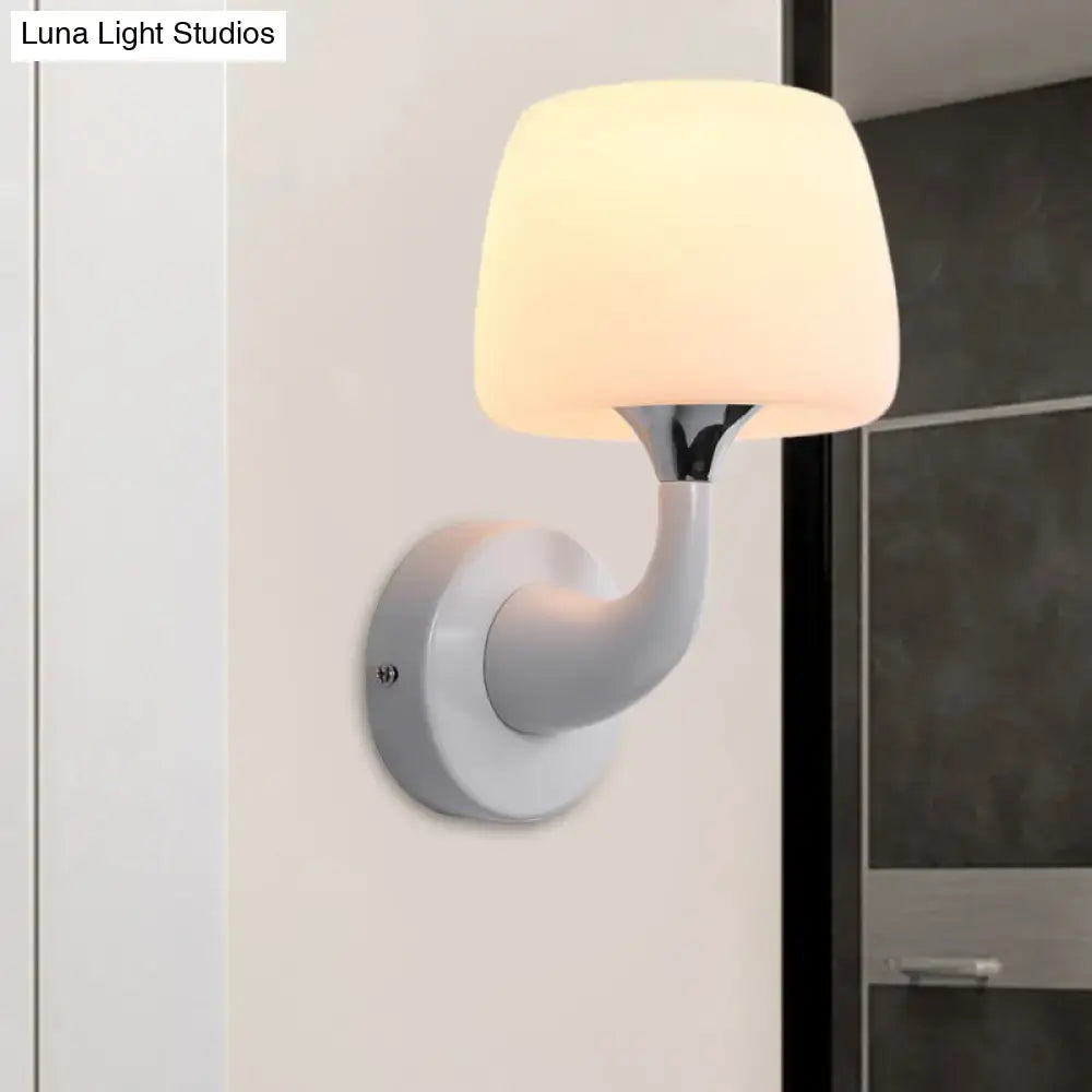 White opal glass wall sconce with curved white arm and chrome accent, warm glow on Tampa Home & Garden Store
