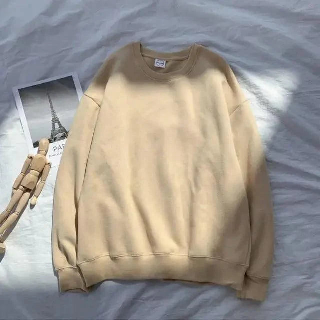 Beige crewneck long-sleeve sweatshirt laid flat on bed with Paris photo nearby on Tampa Home & Garden Store