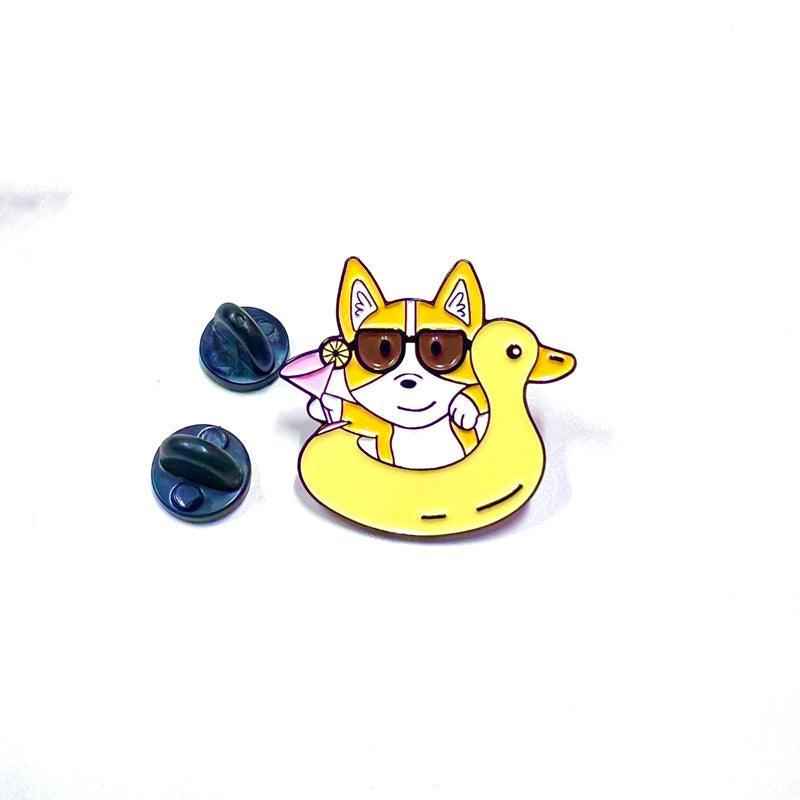 Corgi Floaty enamel pin by Shaketea; yellow inflatable ring and a dog wearing sunglasses on Tampa Home & Garden Store