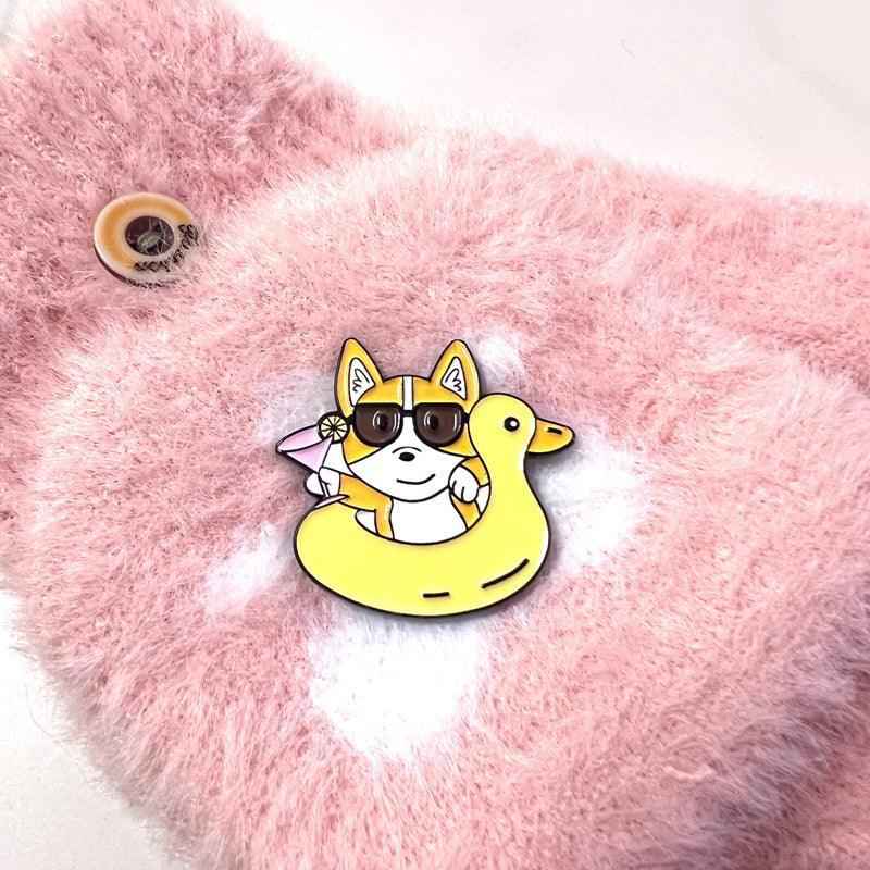 Corgi Floaty enamel pin with yellow duck floatie and sunglasses on pink plush background on Tampa Home & Garden Store