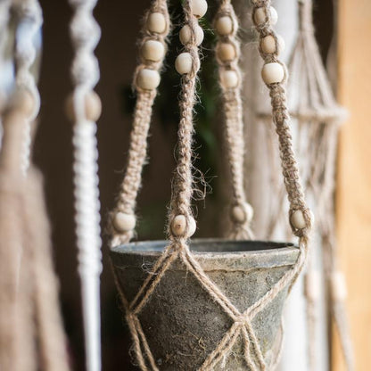 Cotton hemp rope planter hanger with wooden bead accents holding a weathered metal pot on Tampa Home & Garden Store