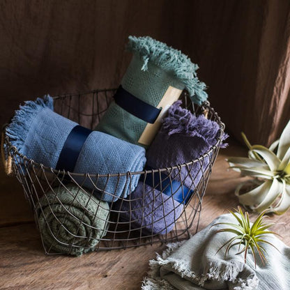 Cotton Throw Sofa Blanket set by RusticReach in blue, sage, and plum (set of 4) in a wire basket on Tampa Home & Garden Store