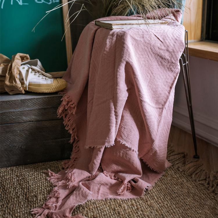 Cotton throw blanket by RusticReach in soft pink with fringed edges draped over chair on Tampa Home & Garden Store