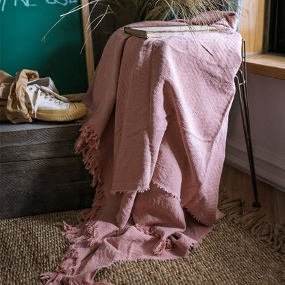 Cotton throw blanket by RusticReach in soft pink with fringed edges draped over chair on Tampa Home & Garden Store