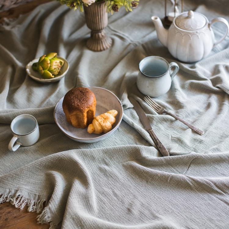 Cotton Throw Sofa Blanket by RusticReach in soft gray, draped over a textured table setting on Tampa Home & Garden Store