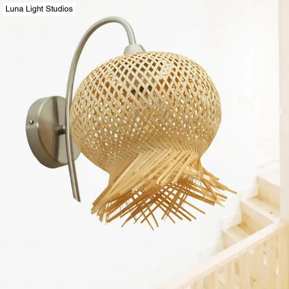 Beige rattan wall sconce with curved metal arm, round woven shade and fringe trim by Decorbites on Tampa Home & Garden Store