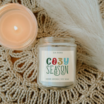 Gia Roma Cozy Season candle, soy wax in a clear glass jar; on beige knitted backdrop on Tampa Home & Garden Store