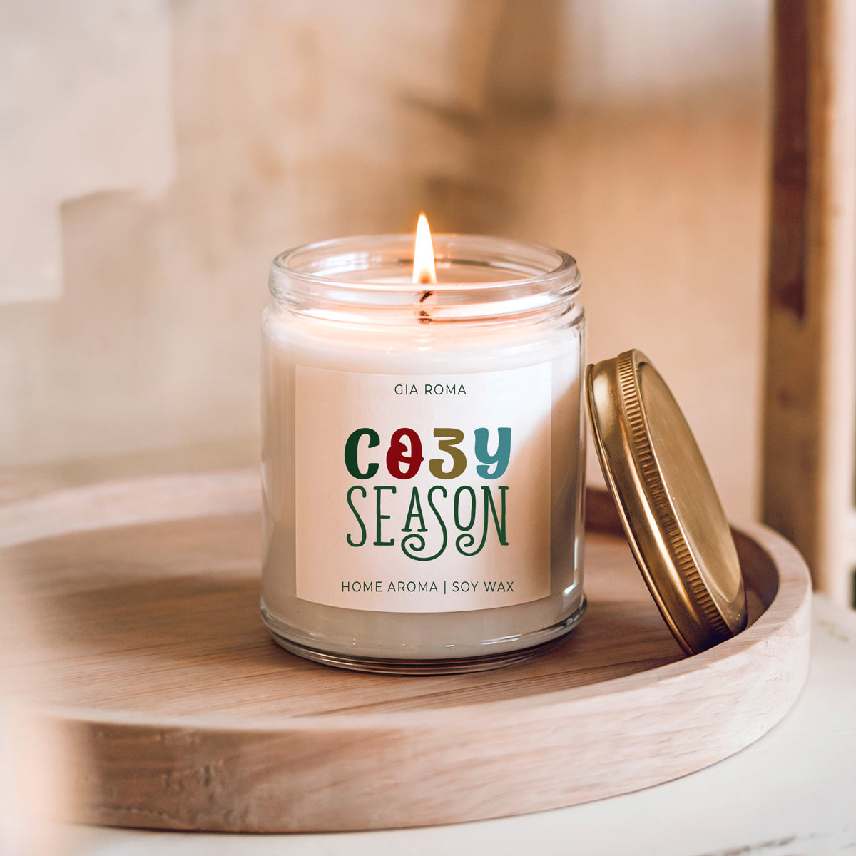 Candle Cozy Season by Gia Roma in a clear glass jar with gold lid, lit on a wooden tray on Tampa Home & Garden Store