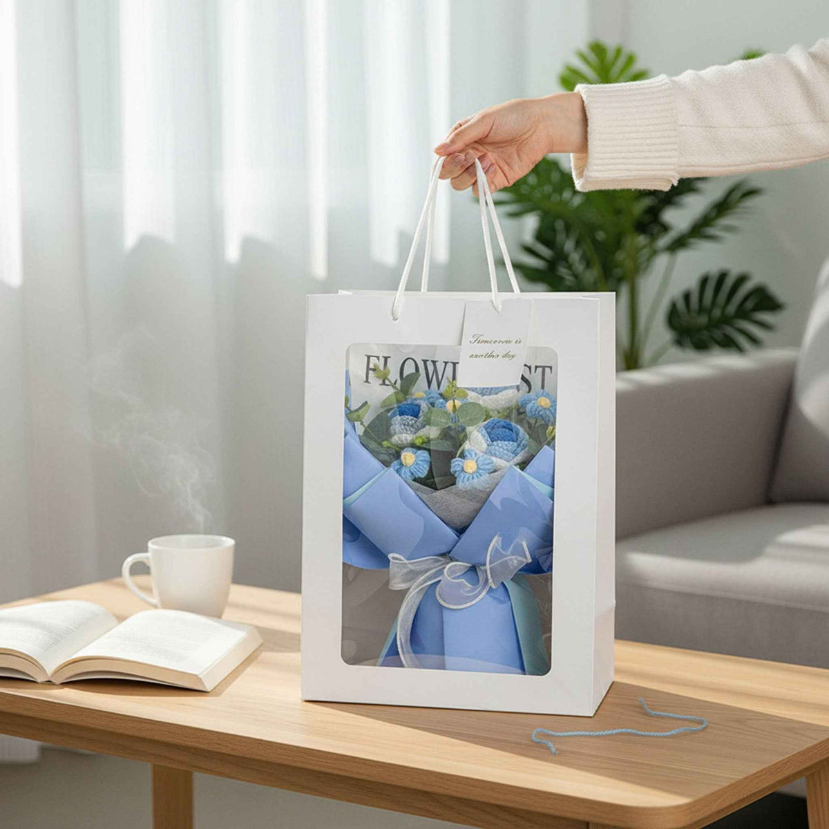 Crochet Rose Bouquet gift bag with blue tissue inside on a table beside an open book on Tampa Home & Garden Store