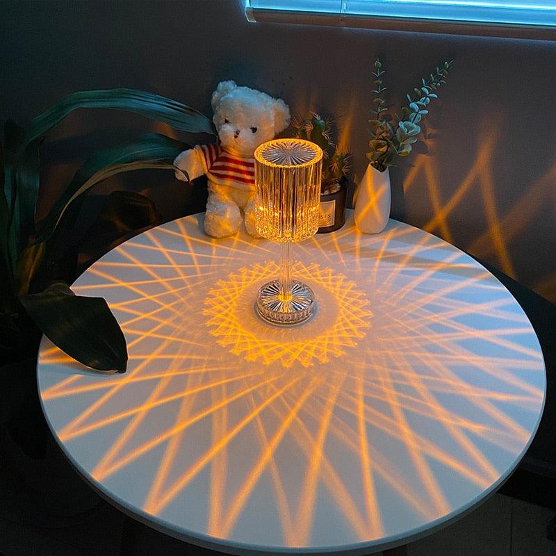 Stevvex crystal table lamp with LED diamond touch base casting warm amber starburst on white table on Tampa Home & Garden Store