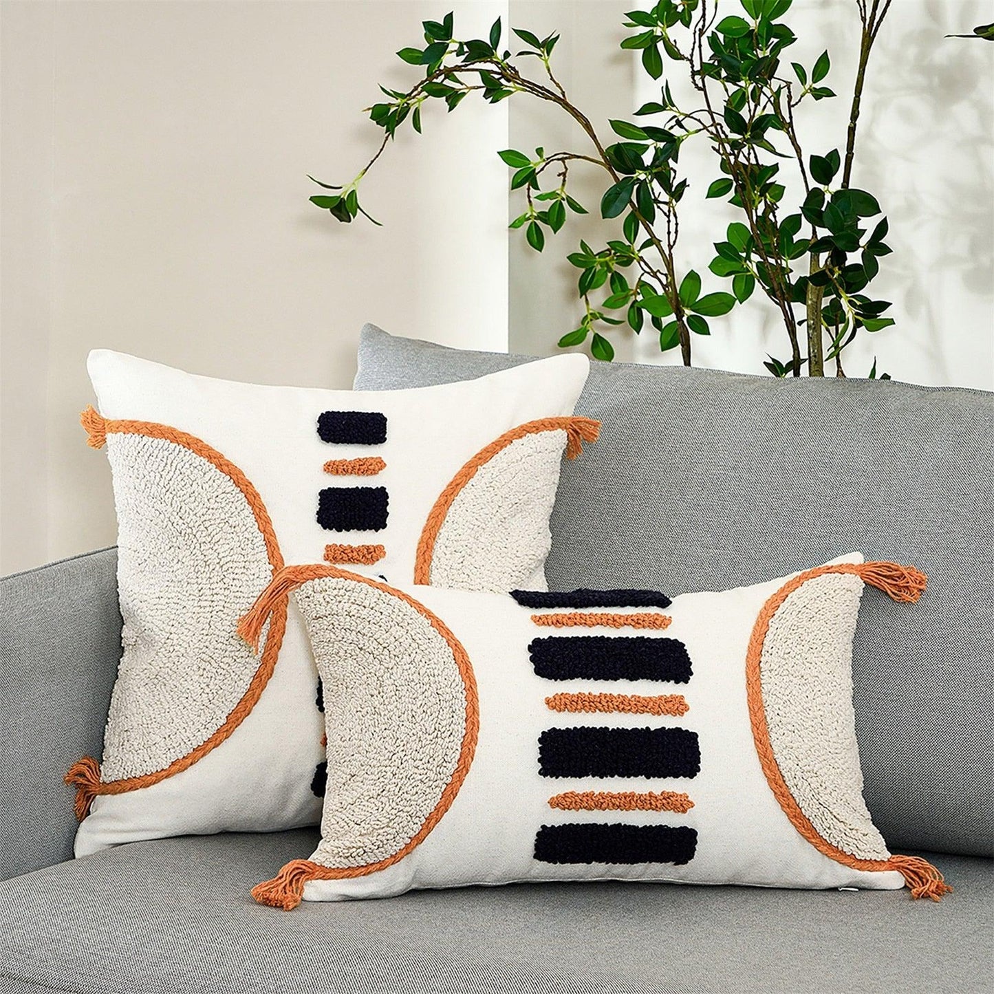 Cushion cover white tufted with orange piping and navy accents, tassel fringe on gray sofa on Tampa Home & Garden Store